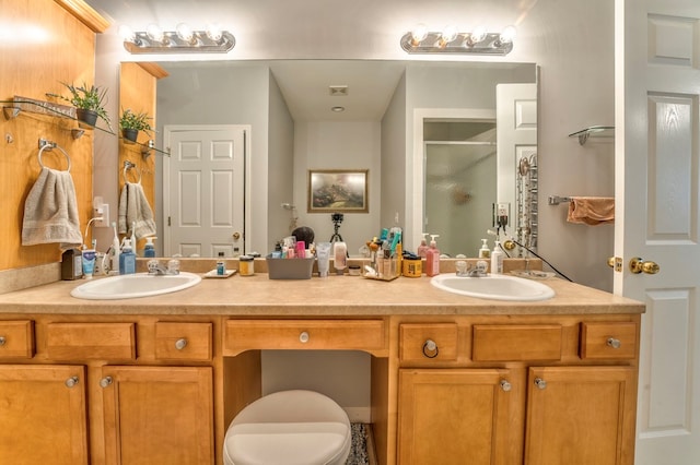 full bath with double vanity, a shower stall, toilet, and a sink