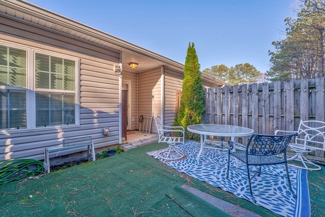 view of patio featuring outdoor dining area and fence