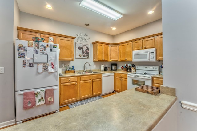 kitchen with brown cabinets, a sink, recessed lighting, white appliances, and light countertops