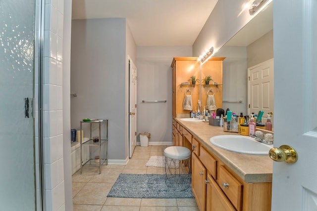 full bathroom with tile patterned flooring, double vanity, baseboards, and a sink