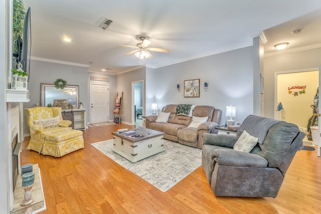 living room featuring visible vents, wood finished floors, a ceiling fan, and ornamental molding