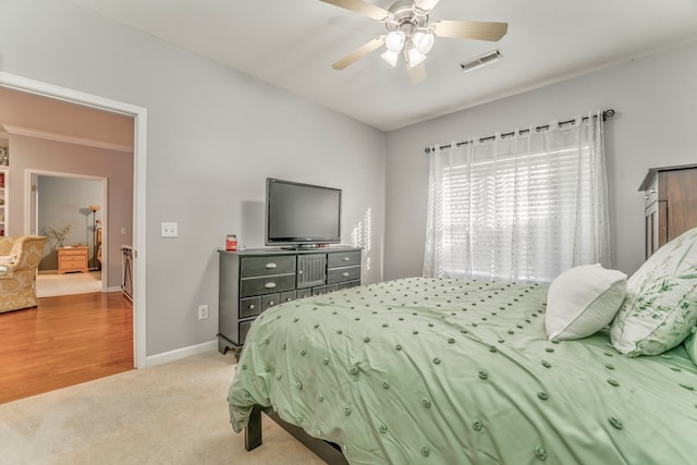 carpeted bedroom featuring visible vents, ceiling fan, and baseboards