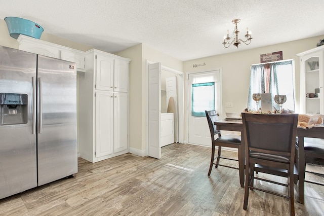 dining space featuring a chandelier, washer / dryer, light hardwood / wood-style flooring, and a textured ceiling