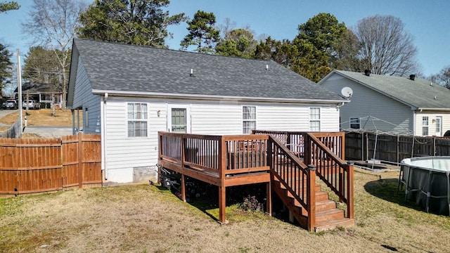 back of property with a lawn and a swimming pool side deck