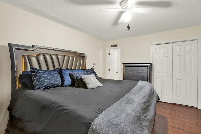 bedroom with ceiling fan, a closet, dark hardwood / wood-style floors, and a textured ceiling