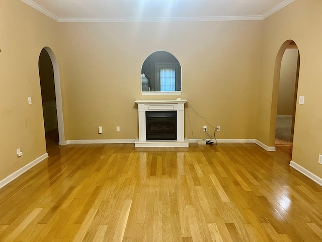 unfurnished living room with crown molding and light wood-type flooring