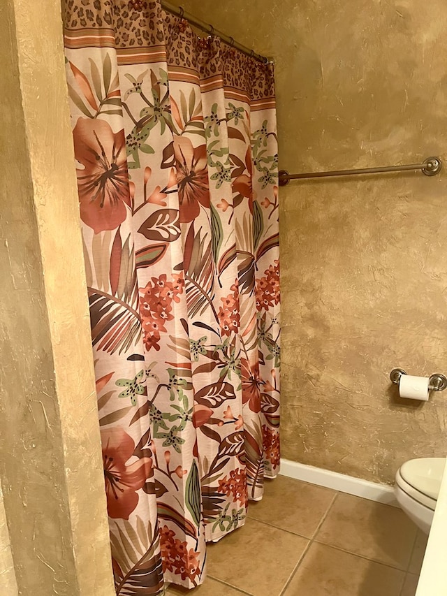 bathroom with toilet and tile patterned flooring