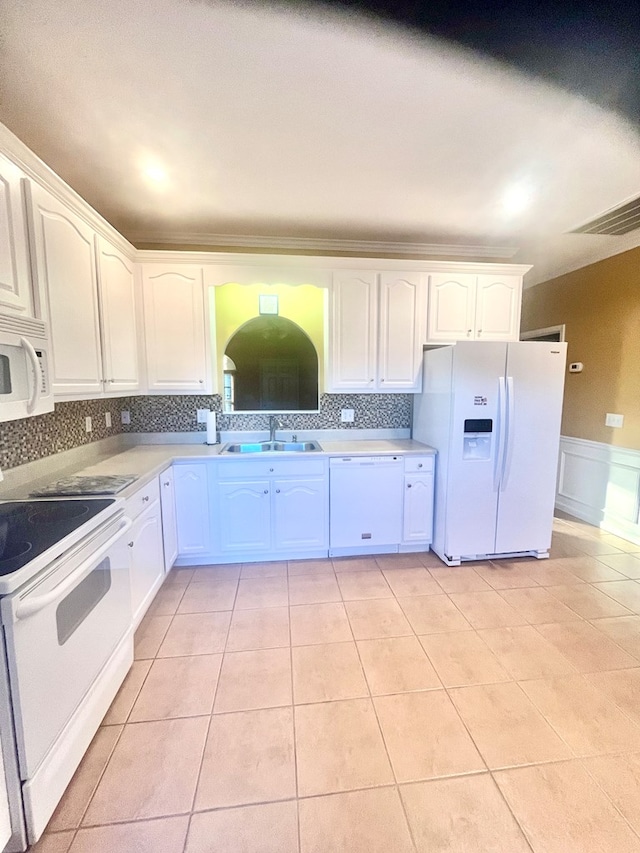 kitchen with white appliances, light tile patterned floors, sink, and white cabinets