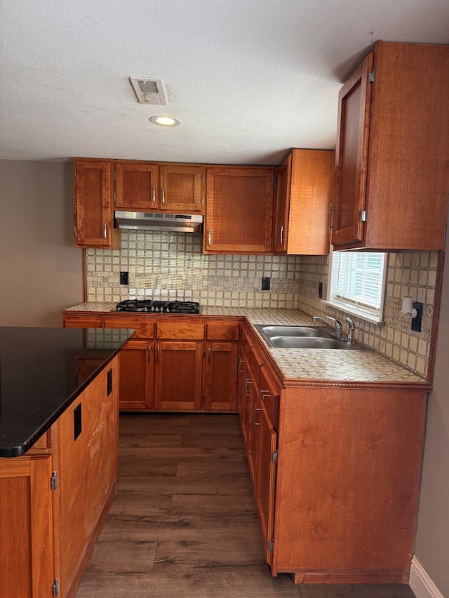 506 Teasley St, Dalton, GA 30721 - kitchen featuring a sink, black gas stovetop, dark wood finished floors, under cabinet range hood, and brown cabinetry