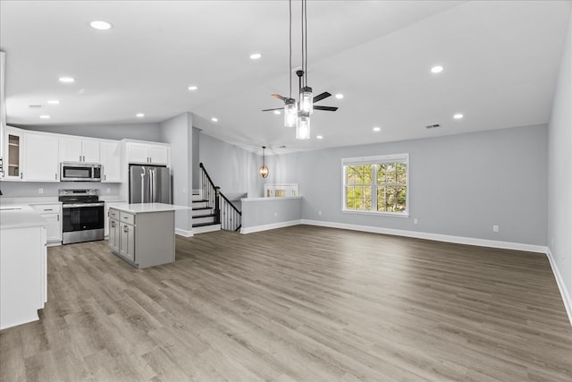 638 Pine Oaks Dr, Tunnel Hill, GA 30755 - kitchen featuring stainless steel appliances, a kitchen island, light countertops, lofted ceiling, and white cabinets