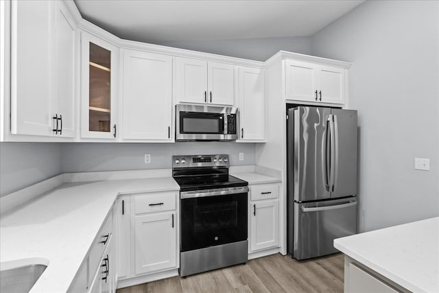 638 Pine Oaks Dr, Tunnel Hill, GA 30755 - kitchen with appliances with stainless steel finishes, light wood finished floors, white cabinets, glass insert cabinets, and light stone counters