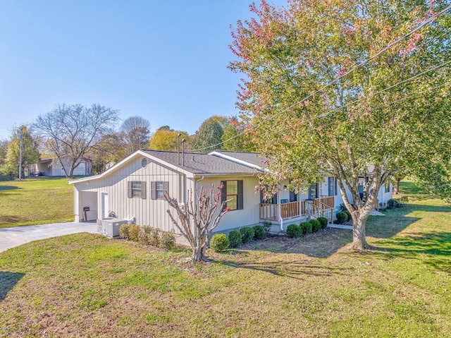 view of home's exterior with a garage, covered porch, and a lawn