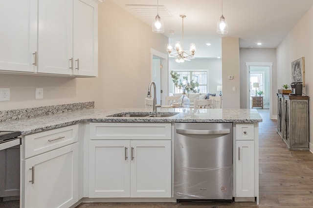 kitchen featuring a peninsula, a sink, white cabinets, stainless steel dishwasher, and a notable chandelier