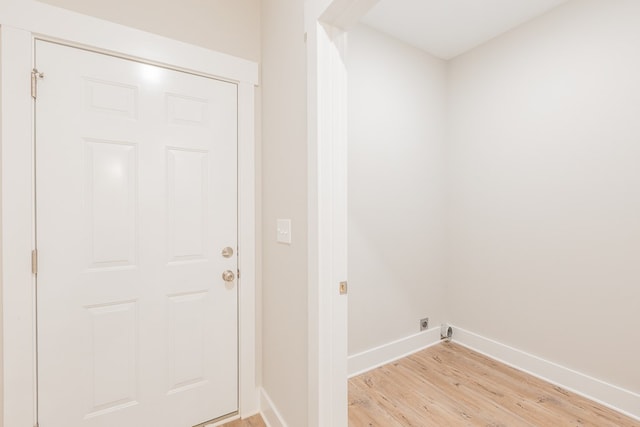 clothes washing area with light wood-type flooring