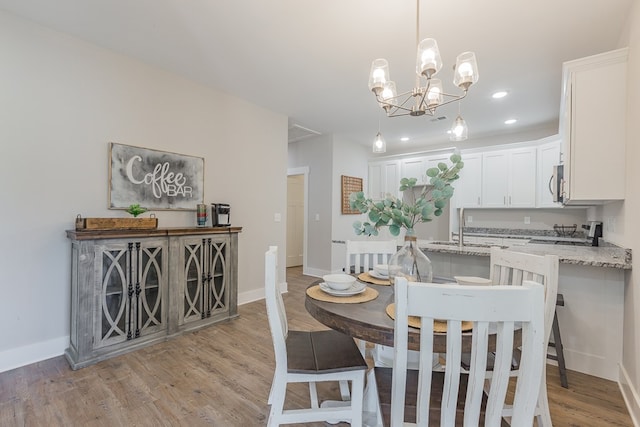 dining room with recessed lighting, baseboards, light wood-style floors, and a chandelier