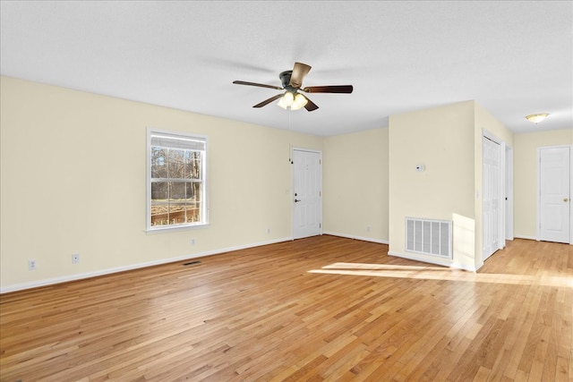 empty room featuring ceiling fan, a textured ceiling, and light wood-type flooring