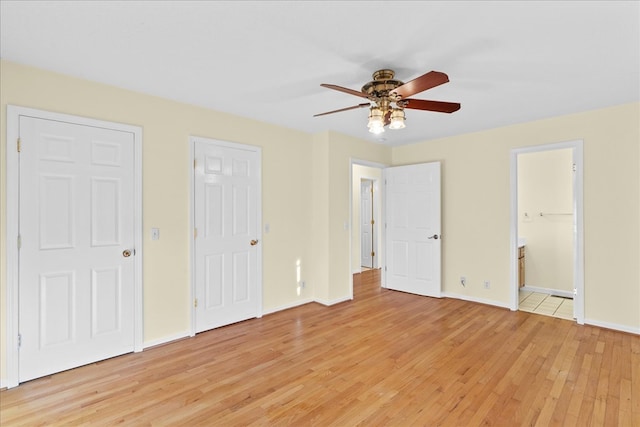 unfurnished bedroom featuring ceiling fan, ensuite bath, and light hardwood / wood-style flooring