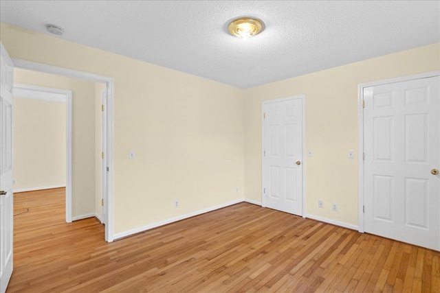 unfurnished bedroom featuring a textured ceiling and light wood-type flooring