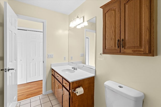 bathroom with tile patterned flooring, vanity, and toilet