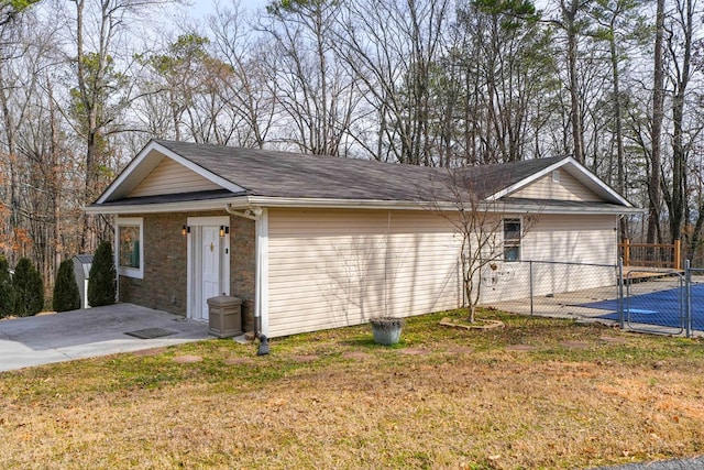 view of front of house with stone siding, a patio, a front lawn, and fence