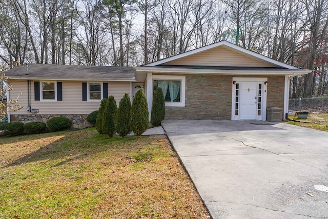 ranch-style home featuring fence, a front yard, crawl space, stone siding, and driveway