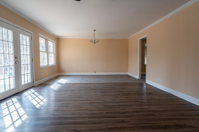 unfurnished room featuring dark wood-type flooring, crown molding, french doors, and a chandelier