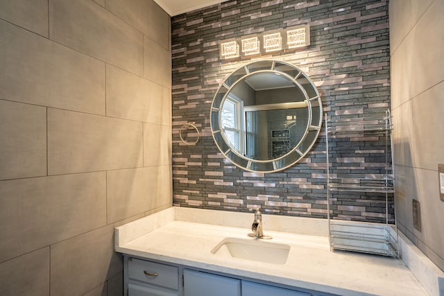 bathroom featuring decorative backsplash, tile walls, and vanity