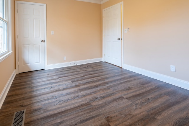 unfurnished room with visible vents, baseboards, and dark wood-style flooring