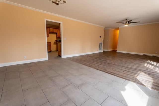 unfurnished room with visible vents, crown molding, baseboards, ceiling fan with notable chandelier, and wood finished floors