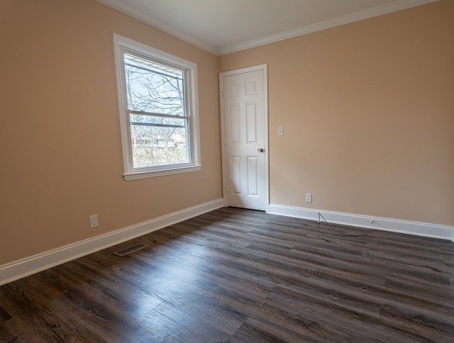 unfurnished room with dark wood finished floors, crown molding, visible vents, and baseboards