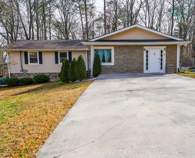 ranch-style house featuring stone siding, driveway, and a front lawn