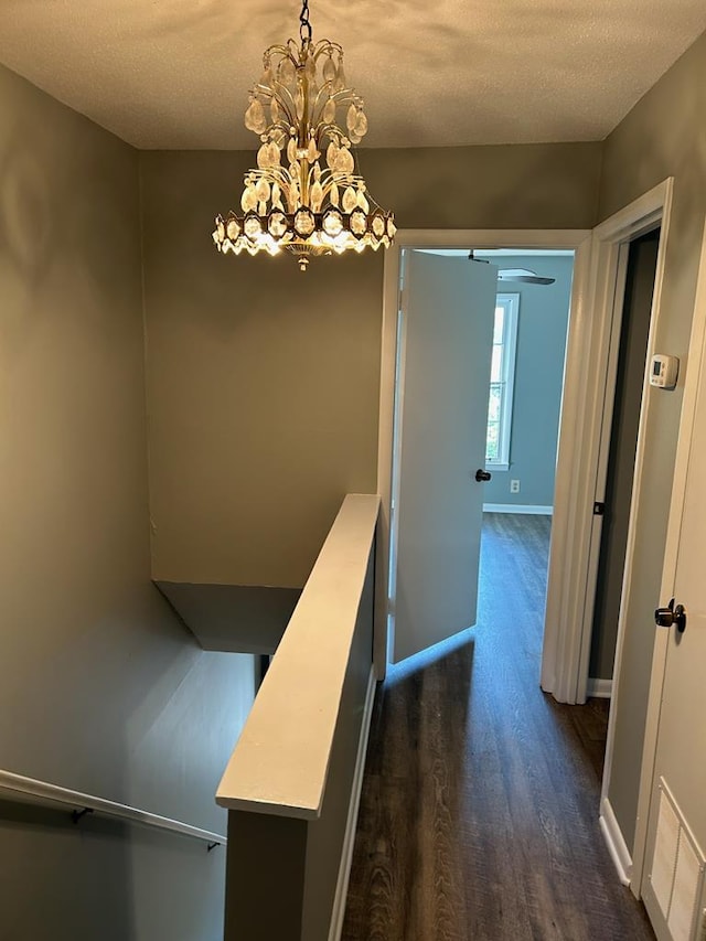 1935 Meadowbrook Cir Unit C, Dalton, GA 30720 - hallway with a notable chandelier, a textured ceiling, baseboards, visible vents, and dark wood-type flooring