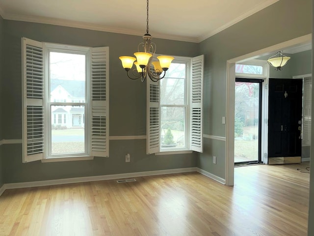 unfurnished dining area featuring plenty of natural light, ornamental molding, and light wood-type flooring