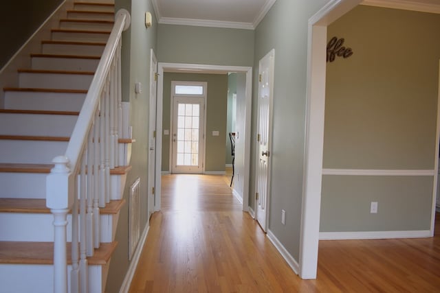 entryway featuring crown molding and light hardwood / wood-style floors