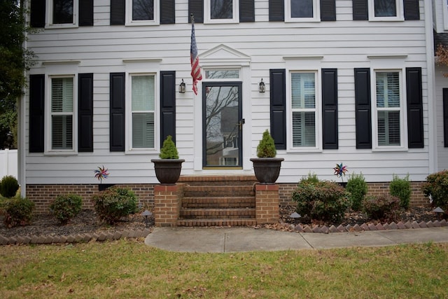 entrance to property with a lawn