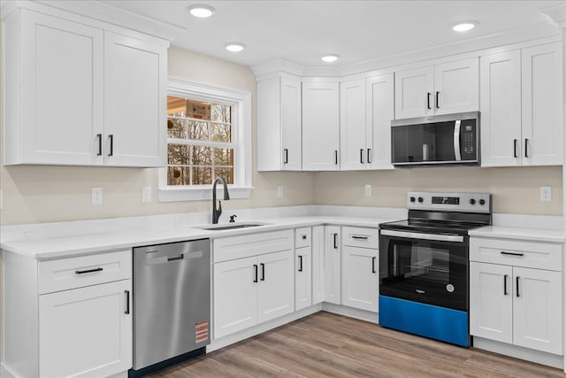 kitchen with recessed lighting, a sink, white cabinetry, and appliances with stainless steel finishes