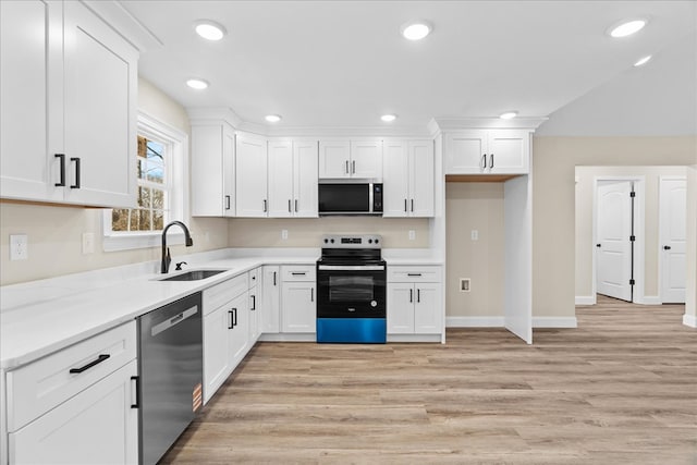 kitchen featuring white cabinets, light wood-style floors, stainless steel appliances, and a sink