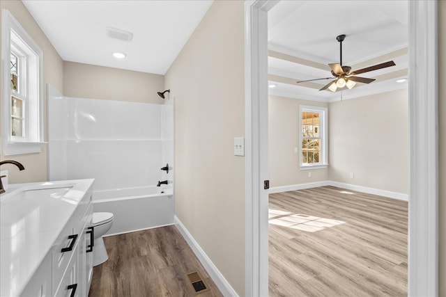 bathroom with a ceiling fan, wood finished floors, vanity, bathtub / shower combination, and toilet