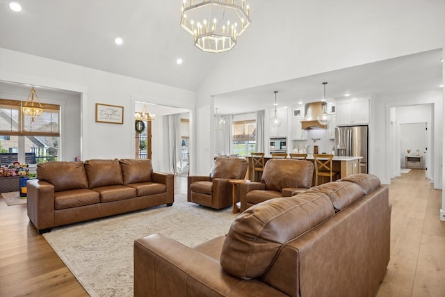 living room with light wood-style flooring, recessed lighting, high vaulted ceiling, and a chandelier