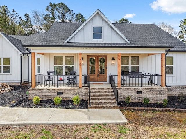 view of front of property with french doors, covered porch, board and batten siding, and roof with shingles