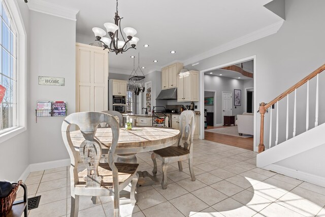 dining space featuring crown molding, light tile patterned floors, and an inviting chandelier