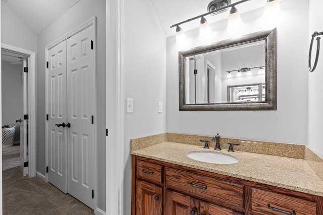 bathroom with lofted ceiling and vanity