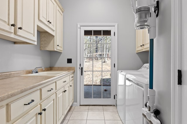 laundry area featuring independent washer and dryer, cabinets, light tile patterned flooring, and sink