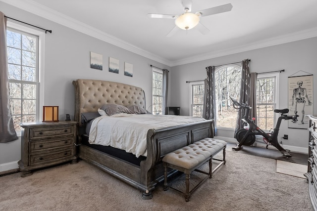 carpeted bedroom featuring crown molding and ceiling fan