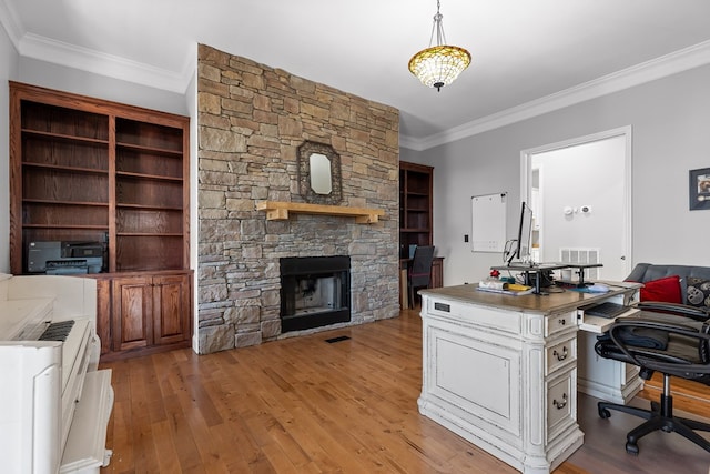 office featuring crown molding, a fireplace, and light wood-type flooring