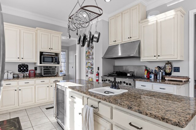 kitchen with a center island, light tile patterned floors, appliances with stainless steel finishes, ornamental molding, and dark stone counters