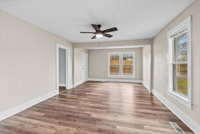 spare room with wood-type flooring, ceiling fan, and a textured ceiling