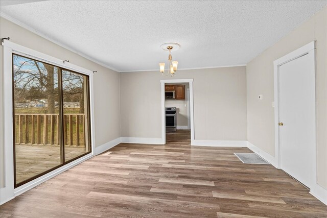 unfurnished dining area with a notable chandelier, a textured ceiling, and light hardwood / wood-style flooring