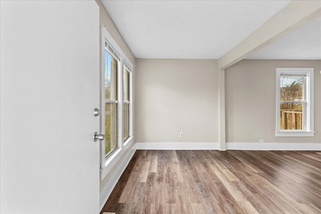 spare room featuring hardwood / wood-style flooring and a textured ceiling