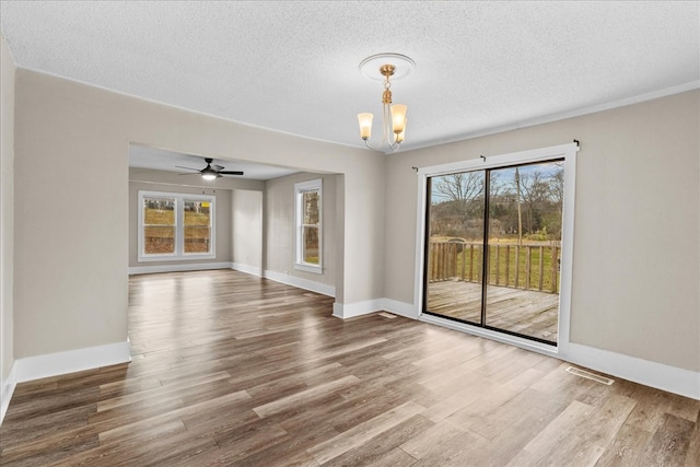 unfurnished room with wood-type flooring, a textured ceiling, and a notable chandelier